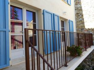 une maison avec portes bleues et garde-corps dans l'établissement Gite de la Place, à La Palud-sur-Verdon