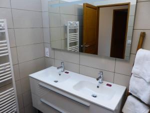 La salle de bains est pourvue d'un lavabo blanc et d'un miroir. dans l'établissement Gite de la Place, à La Palud-sur-Verdon