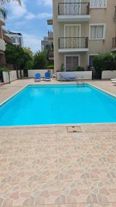 Una gran piscina azul frente a un edificio en Laertis Apartments - by IMH Travel & Tours, en Pafos