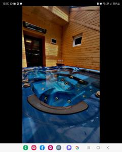 Habitación con una gran bañera azul. en Cabana Patru Brazi, en Stana de Vale