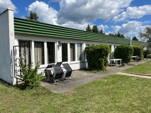 un groupe de chaises assis à l'extérieur d'un bâtiment dans l'établissement Ferienpark Stausee Quitzdorf, à Kollm