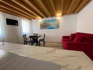a living room with a red couch and a table at Elva Suite House in Chioggia