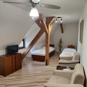 um quarto no sótão com 2 camas e uma televisão em Smolenický zámok em Smolenice