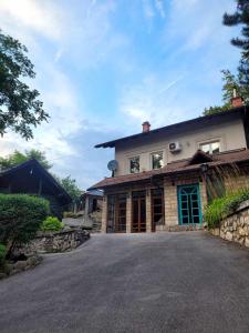 a house with a driveway in front of it at Nature Guest House Sarajevo in Sarajevo