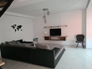 uma sala de estar com um sofá e uma televisão em Nika em Bilice