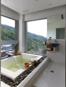 baño con bañera y ventana grande en Hotel Double One, en Taipéi