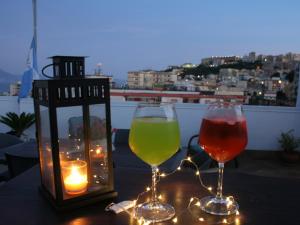 zwei Weingläser auf einem Tisch mit einer Kerze in der Unterkunft Home Napulè in Neapel