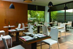 a dining room with tables and white chairs at Hotel Double One in Taipei