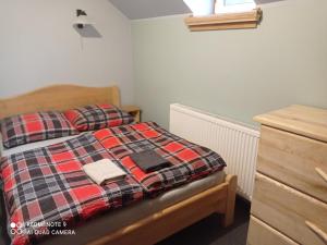 a bedroom with a bed with a plaid blanket at Apartamenty w Karkonoszach in Lubawka