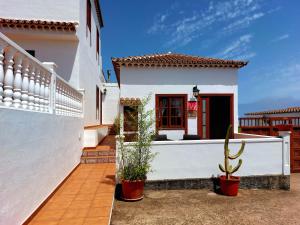 een wit huis met potplanten ervoor bij La Roseta in Barlovento