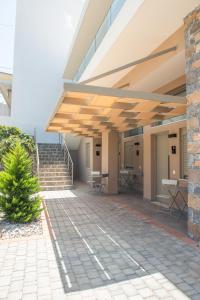ein Gebäude mit einer Terrasse mit Tischen und Stühlen in der Unterkunft Mylos Luxury Apartment 4 in Agios Nikolaos