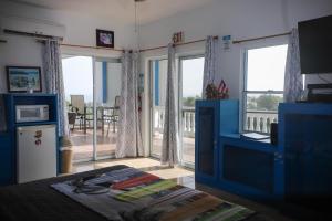 une chambre avec un lit et une cuisine avec des fenêtres dans l'établissement Vista del Mar terrace with pool table and views, à Rincon
