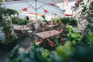 an outdoor patio with wooden tables and chairs and umbrellas at Gästehaus Korf in Unkel
