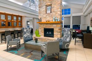 a lobby with a fireplace and chairs and a bar at Residence Inn Port St Lucie in Port Saint Lucie