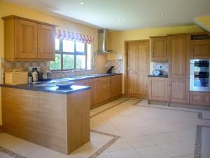 a large kitchen with wooden cabinets and a counter top at Tra Gheal in Kilmore Quay