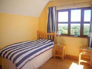 a small bedroom with a bed and a window at Tra Gheal in Kilmore Quay