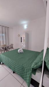 a bedroom with a green bed and a table at JACY AP GOSTOSO in São Miguel do Gostoso