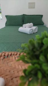 a green bed with two towels and a green couch at JACY AP GOSTOSO in São Miguel do Gostoso