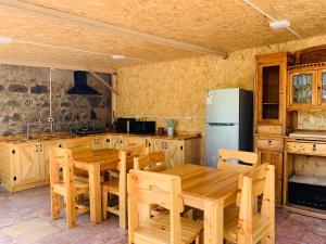 a kitchen with wooden tables and a refrigerator at Green Camp eco-rural and civil society tourism center 
