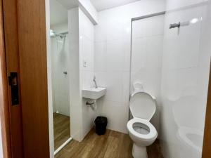 a white bathroom with a toilet and a sink at Loft Mirante 3224 in Sao Paulo