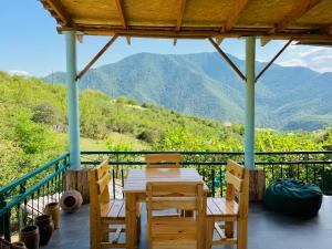 a table and chairs on a porch with a view of mountains at Green Camp eco-rural and civil society tourism center 