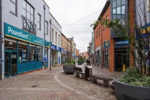 an empty city street with benches and buildings at LiveStay-Modern & Stylish Apartments in Didcot in Didcot