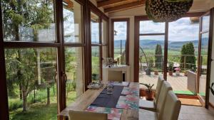 a dining room with a table and a large window at Panoráma Apartman Pilisszántó in Pilisszántó