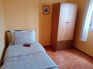 a small bedroom with a bed and a cabinet at Casa Palmés in Valles de Ortega