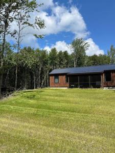 una cabaña en medio de un campo junto a un bosque en Vermont Scandinavian Chalet-Courchevel en Wolcott