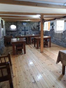 een grote kamer met houten vloeren en houten tafels bij Guesthouse Solomon in Chvibiani