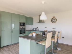 a kitchen with green cabinets and a table with chairs at Beach House in Gorey +15 photos