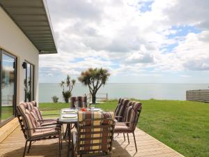 a table and chairs on a patio with a view of the ocean at Beach House in Gorey