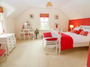 a bedroom with a red and white bed and a desk at Glasmor Country House in Fieries