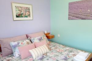 a bedroom with a bed with pink and purple pillows at Sobe Zimmer Rooms Živčić in Karlovac