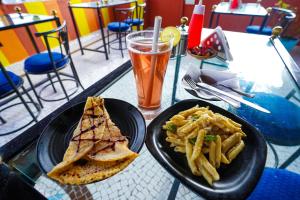 a table with a sandwich and french fries and a drink at Inda Heritage Guest House in Jodhpur