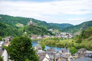 a view of a town with a river and mountains at Moselromantik Hotel Kessler Meyer - Adults Only in Cochem