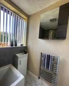 Rowley Regis的住宿－Entire 2 bedroom house.，一间带水槽和镜子的浴室