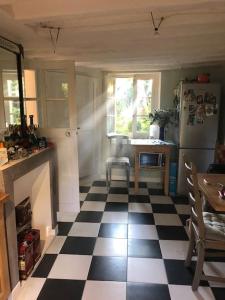 uma cozinha com piso em xadrez preto e branco em Grande maison avec jardin arboré em Survilliers