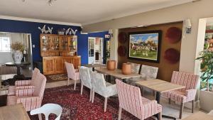 a restaurant with tables and chairs in a room at The Mandyville Jeffreys Bay in Jeffreys Bay