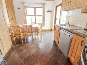 a kitchen with a table and a sink and a table and chairs at Clogher Cottage in Doonbeg