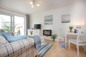 una sala de estar con un sofá y una mesa en The Sail Loft, en Sidmouth