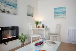 Una sala de estar con chimenea y una mesa. en The Sail Loft, en Sidmouth 16 fotos más
