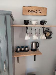a shelf with pots and pans and a clock at Keikei’sHaven in Gros Islet