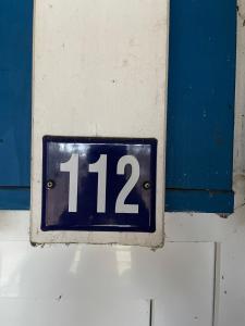 um sinal com o número na parede em Seeblick Wohnung 112 mit Ostseeblick em Ostseebad Koserow