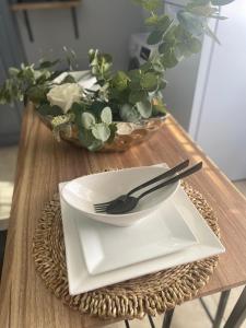 a table with a plate and fork and a bowl of flowers at Keikei’sHaven in Gros Islet