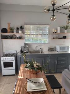 a kitchen with a table and a stove at Keikei’sHaven in Gros Islet