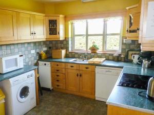a kitchen with a sink and a washing machine at Reeks Cottage in Killorglin
