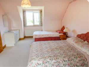 a bedroom with two beds and a window at Reeks Cottage in Killorglin