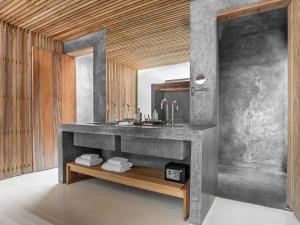 a bathroom with a concrete sink and a mirror at KA BRU Beach Boutique Hotel in Barra Grande