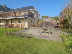 a house with a picnic table in the yard at Bluebell House and Gardens in Rossbrin